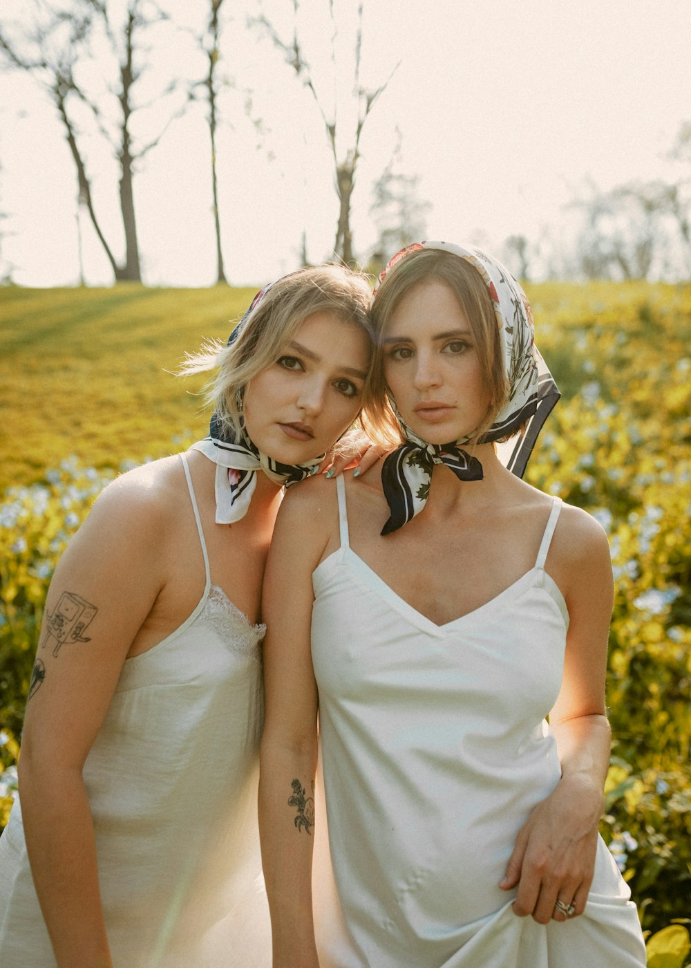 two women in white dresses standing next to each other