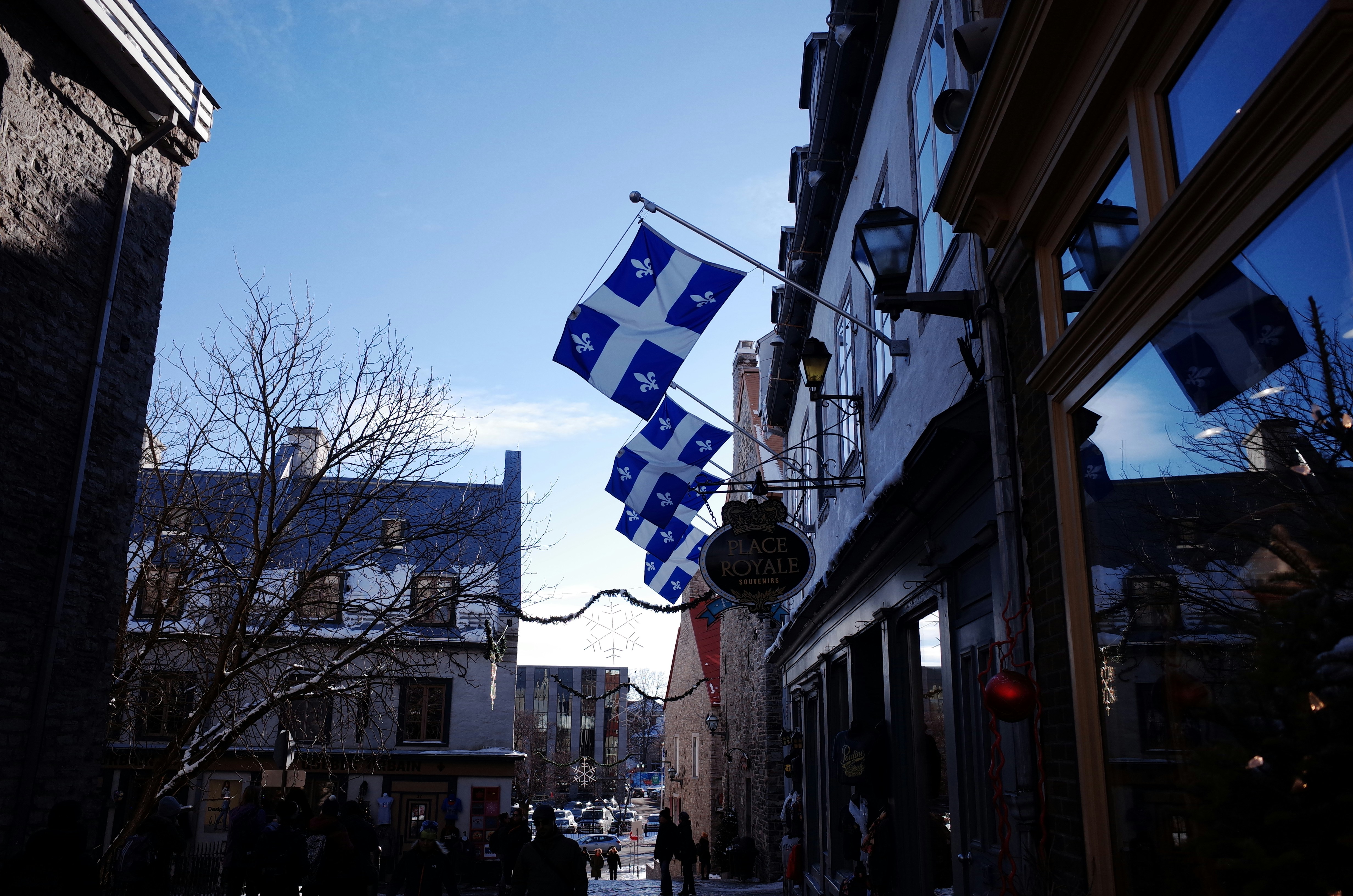 a city street with a flag hanging from the side of a building