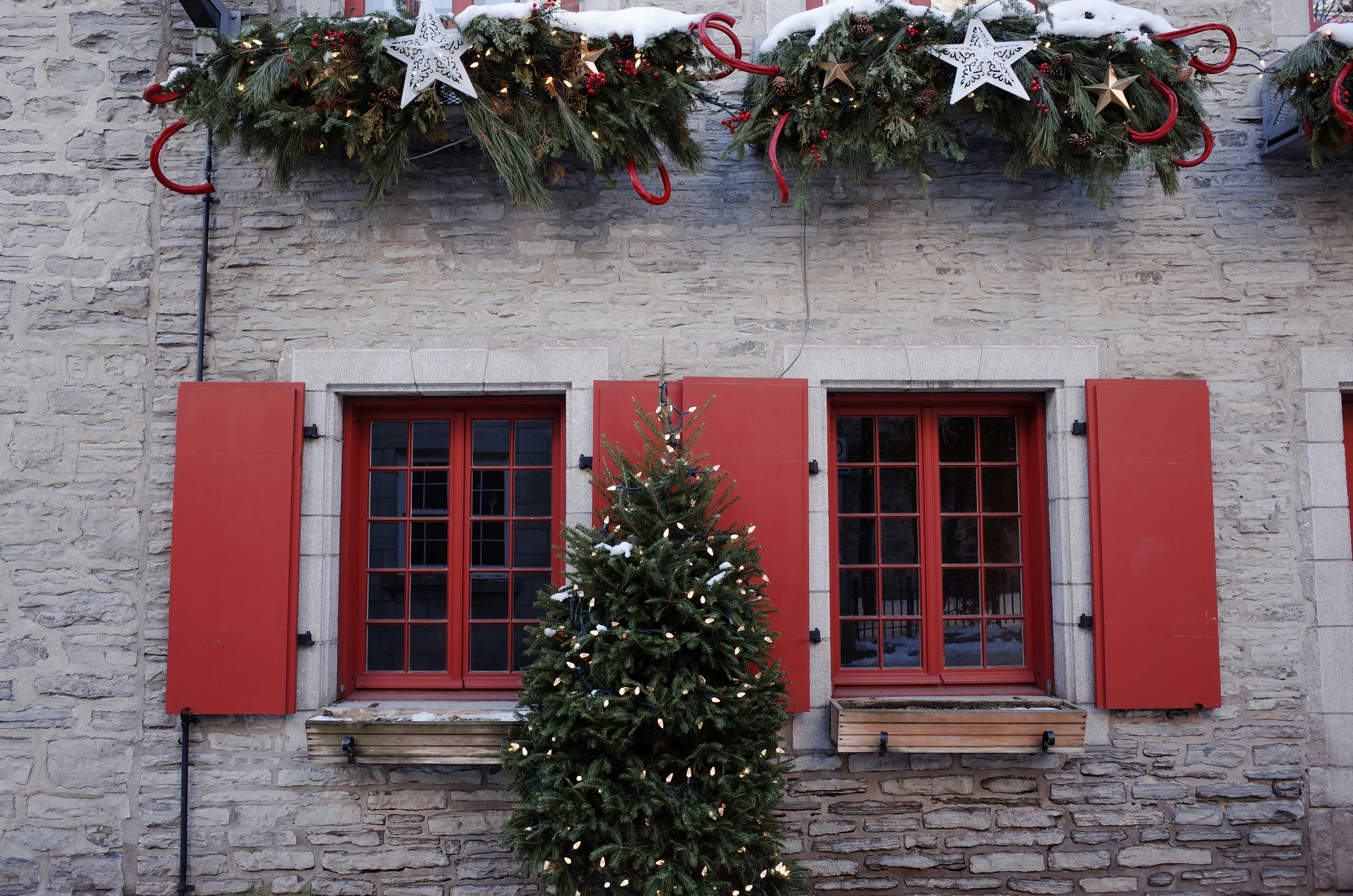 a building with red shutters and christmas decorations