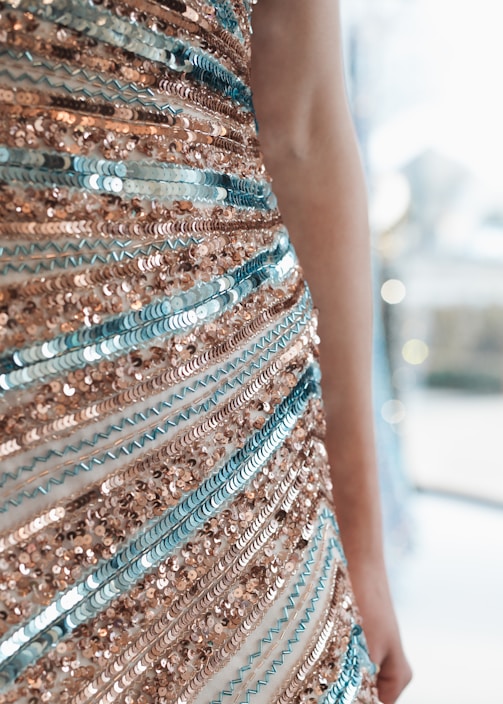 Close-up of a shimmering silver cocktail dress draped on a mannequin, highlighting intricate beadwork.