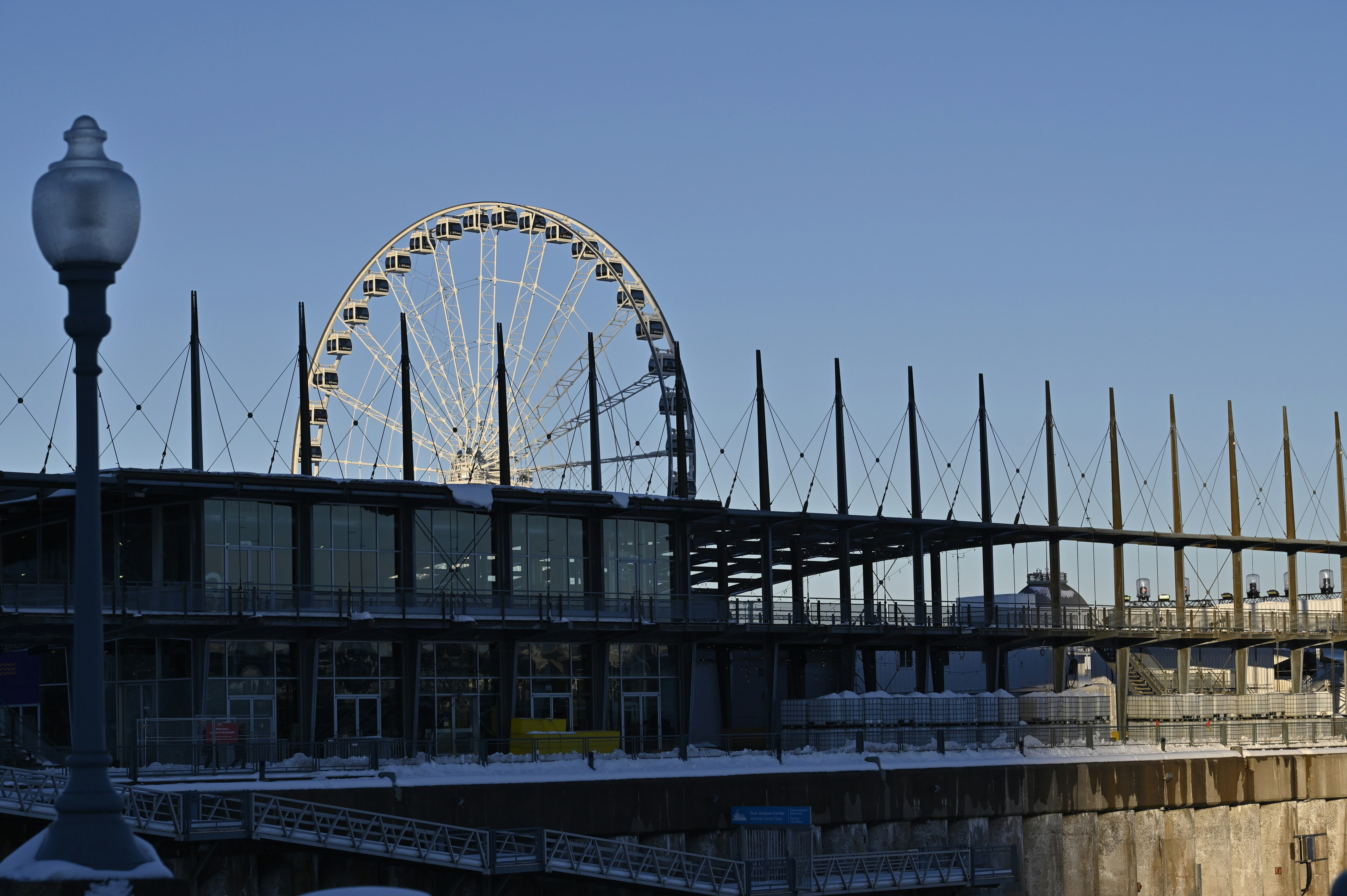 a ferris wheel sitting next to a building under a blue sky