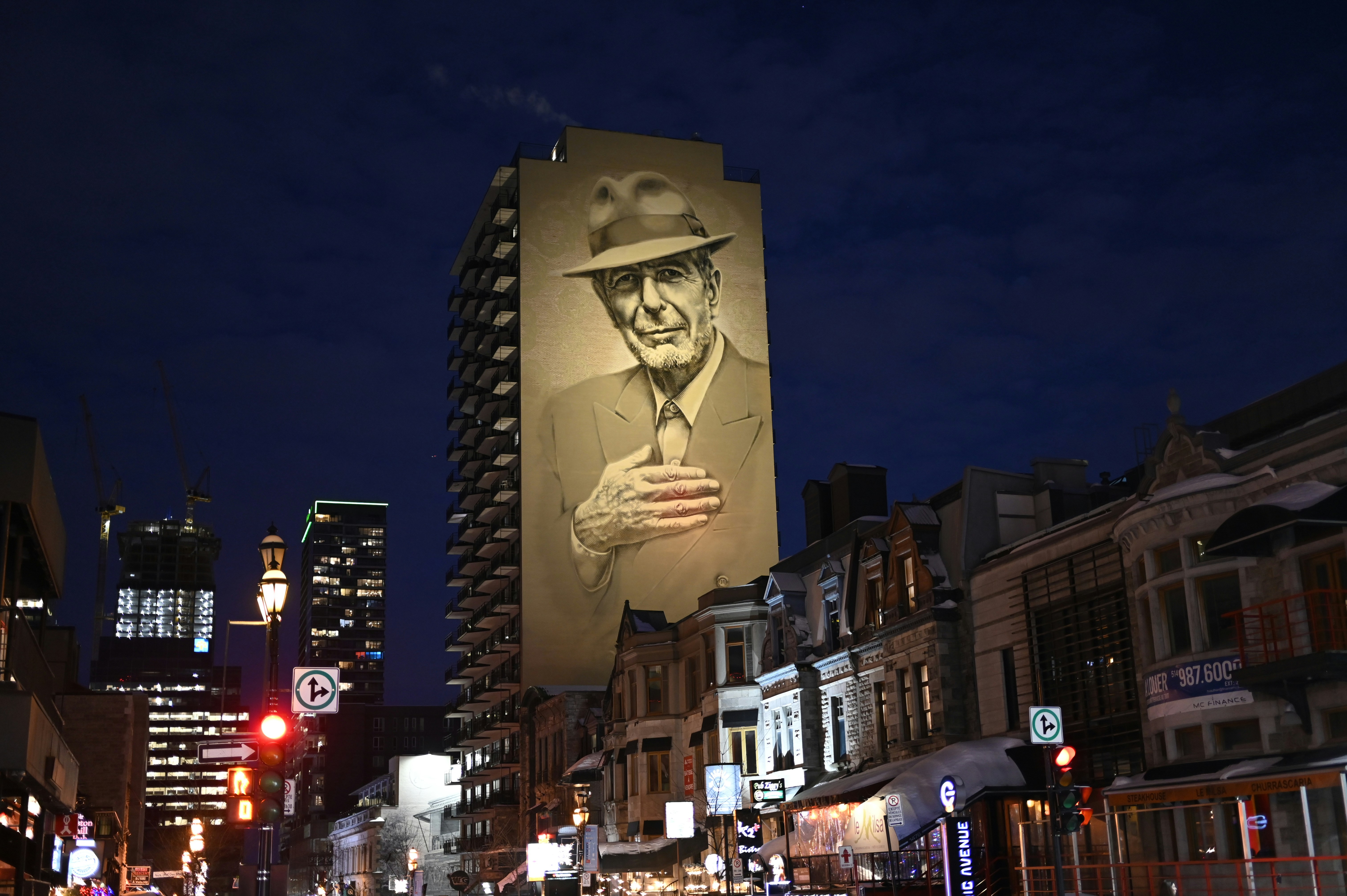 a large billboard of a man in a hat on a city street