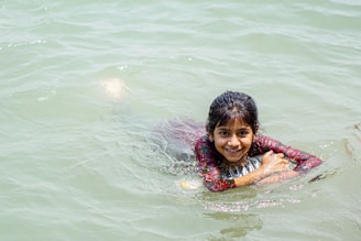 Smiling young swimmer holding a silver medal on the podium.