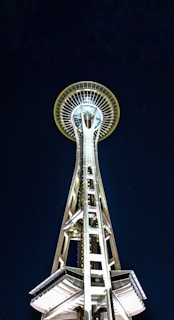 Side view of a solar lighting tower with its mast glowing brightly against the dark backdrop.