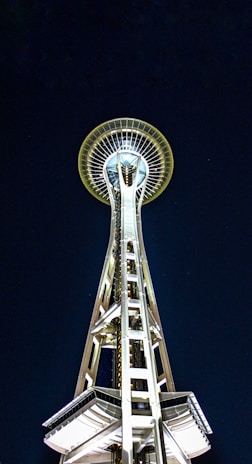 Side view of a solar lighting tower with its mast glowing brightly against the dark backdrop.