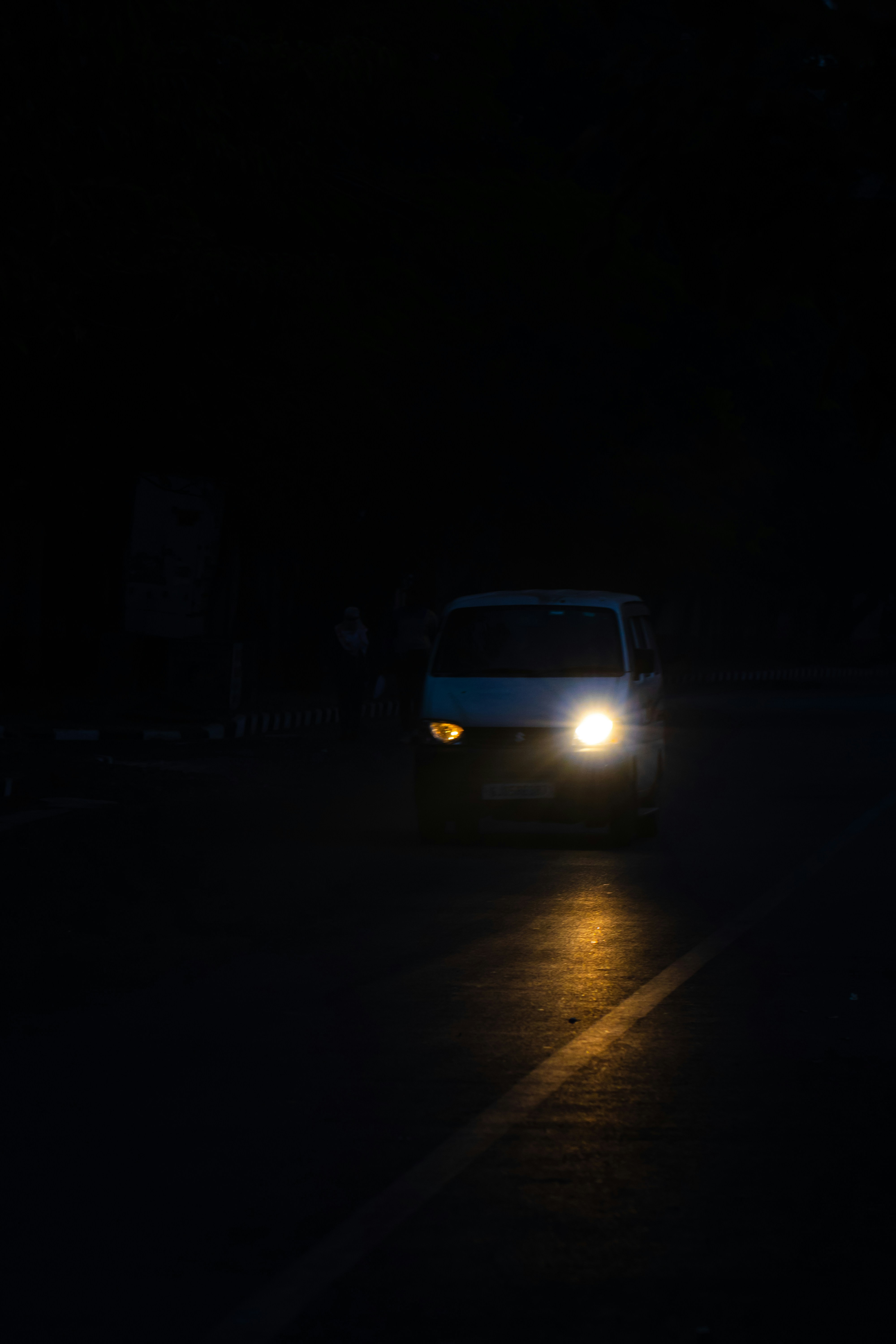 uma van branca dirigindo por uma rua à noite