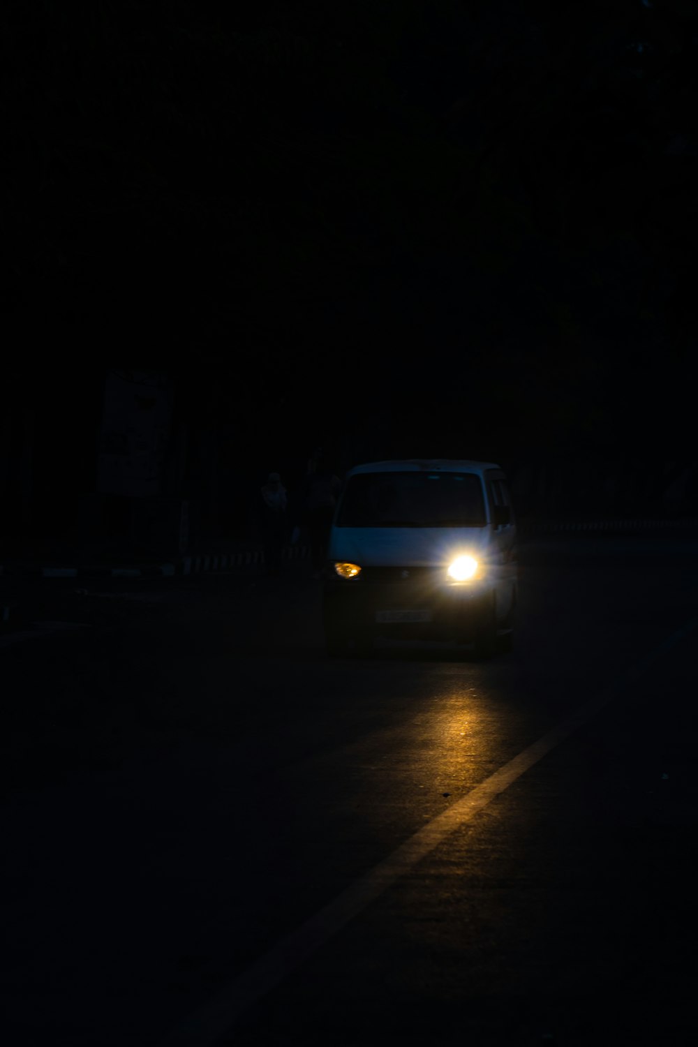 a white van driving down a street at night