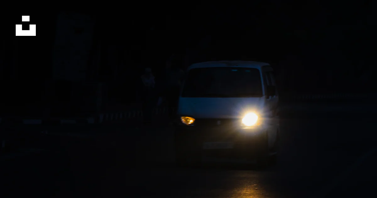 Foto Una Camioneta Blanca Conduciendo Por Una Calle Por La Noche foto-una-camioneta-blanca-conduciendo-por-una-calle-por-la-noche