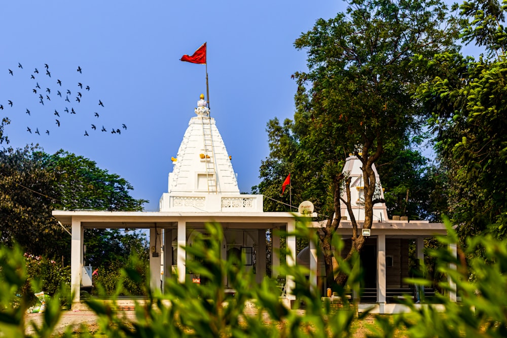 a white building with a red flag on top of it