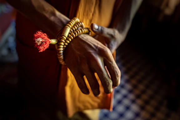 A serene photo of a traveler holding a prayer bead, symbolizing spiritual journey and connection.