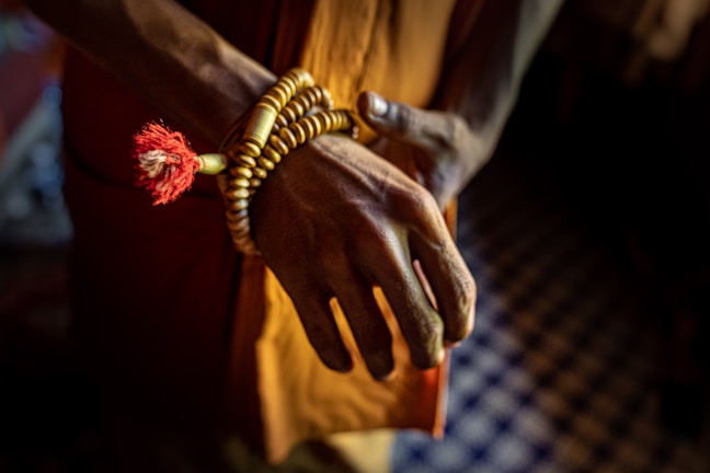 A close-up of a tasbih (prayer beads) resting gently on a wooden table.