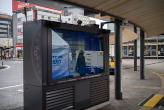 A vibrant mobile digital LED sign mounted on a truck parked outside a modern apartment complex.