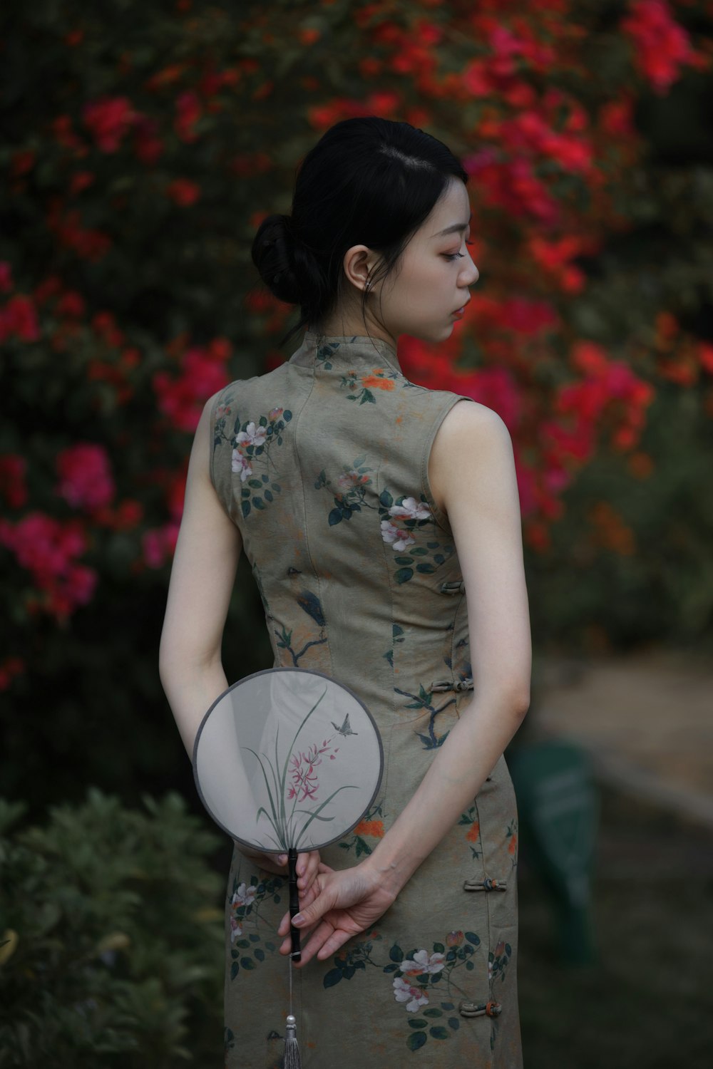 a woman in a dress holding a fan