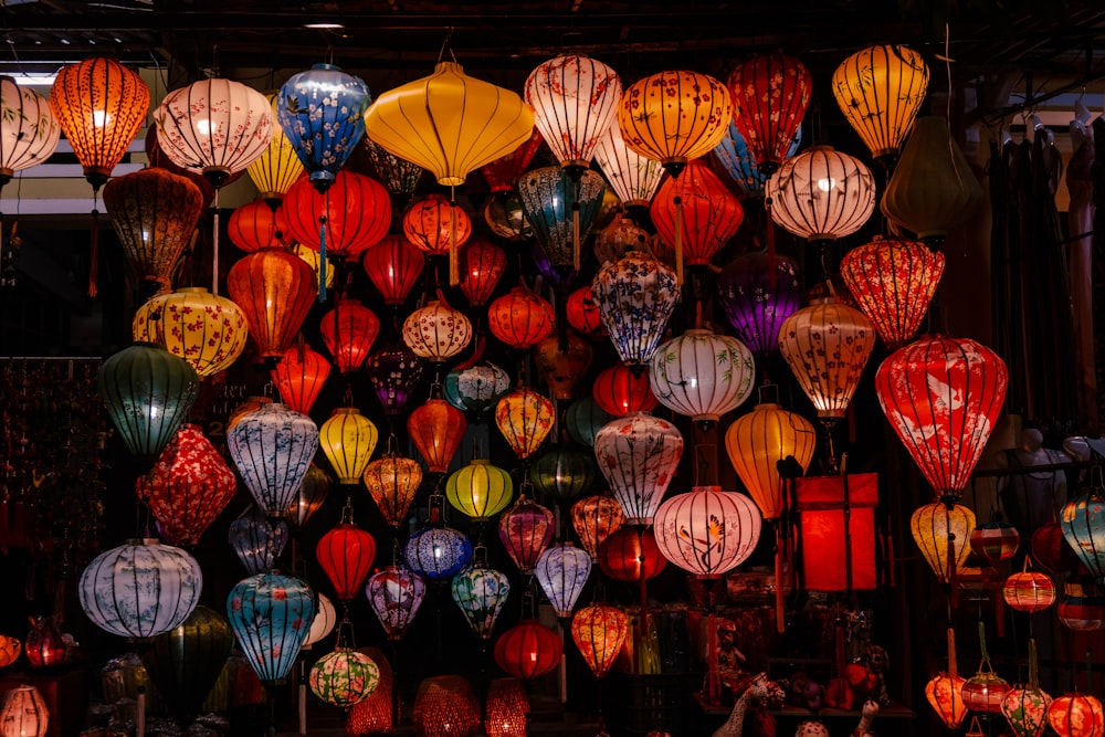 a bunch of lanterns are hanging in a room