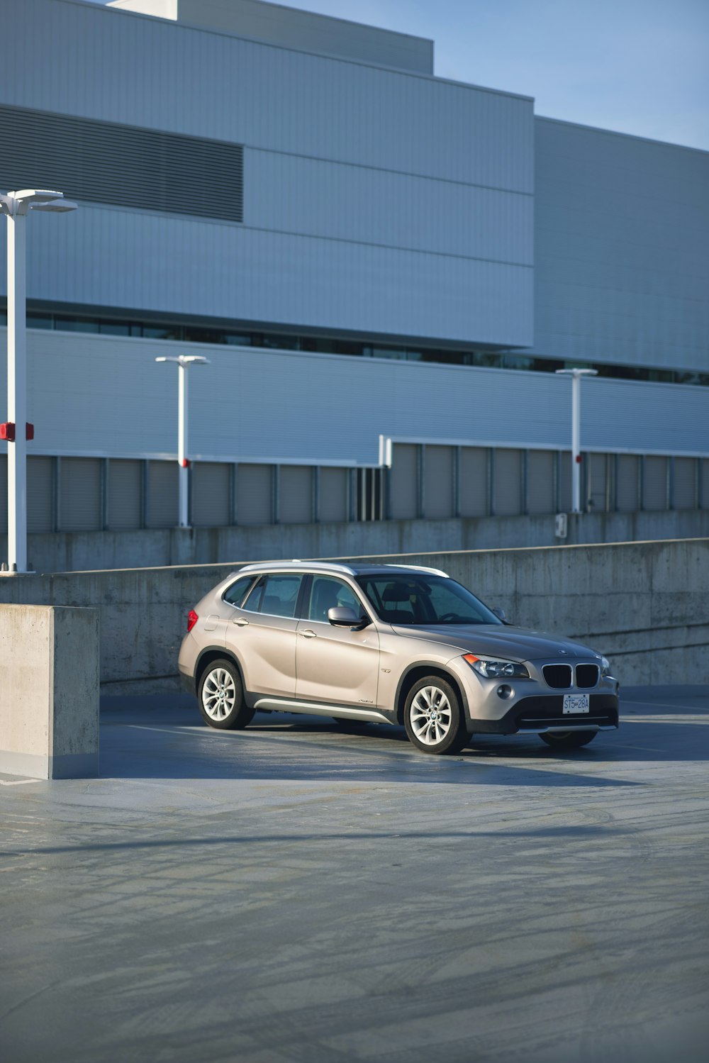 a silver car parked in a parking lot next to a building