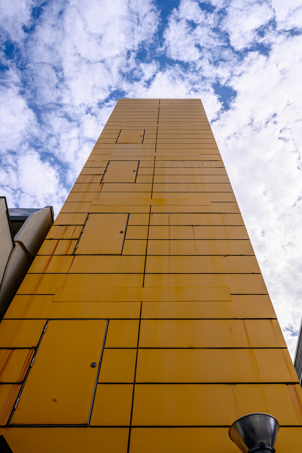 a tall yellow building with a street light next to it