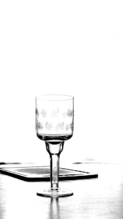 a black and white photo of a glass on a table