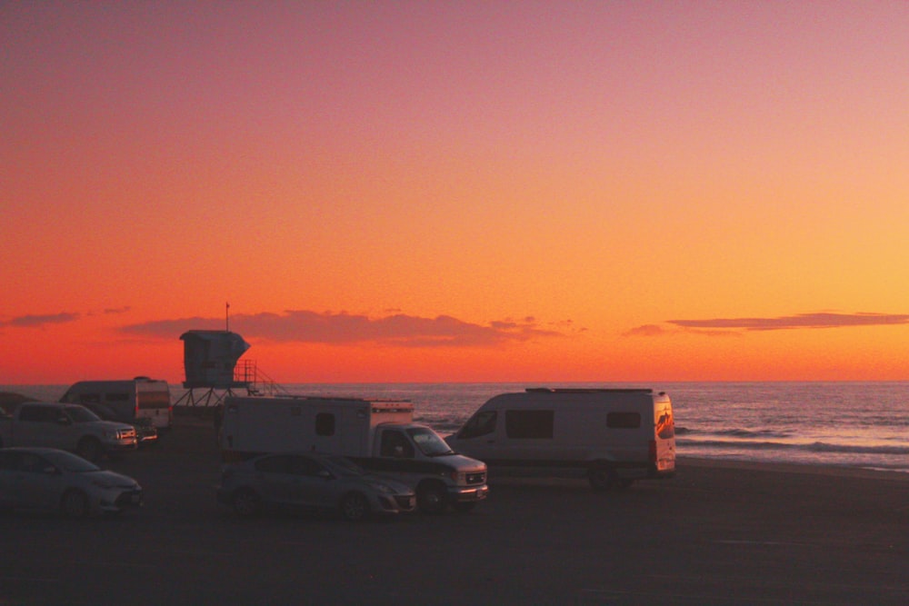 a group of cars parked on top of a sandy beach