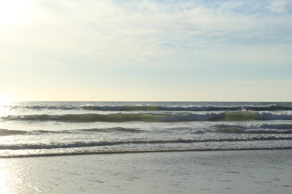 a person walking on the beach with a surfboard