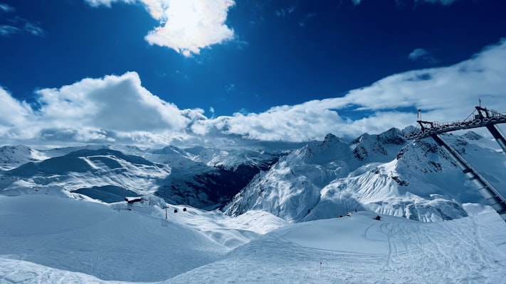 Skiers on high alpine terrain under a clear winter sky