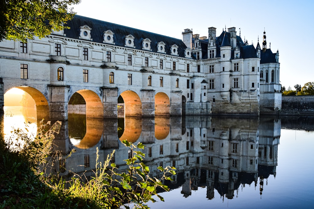 un château avec un pont sur un plan d’eau