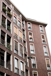 a tall building with balconies and plants on the balconies