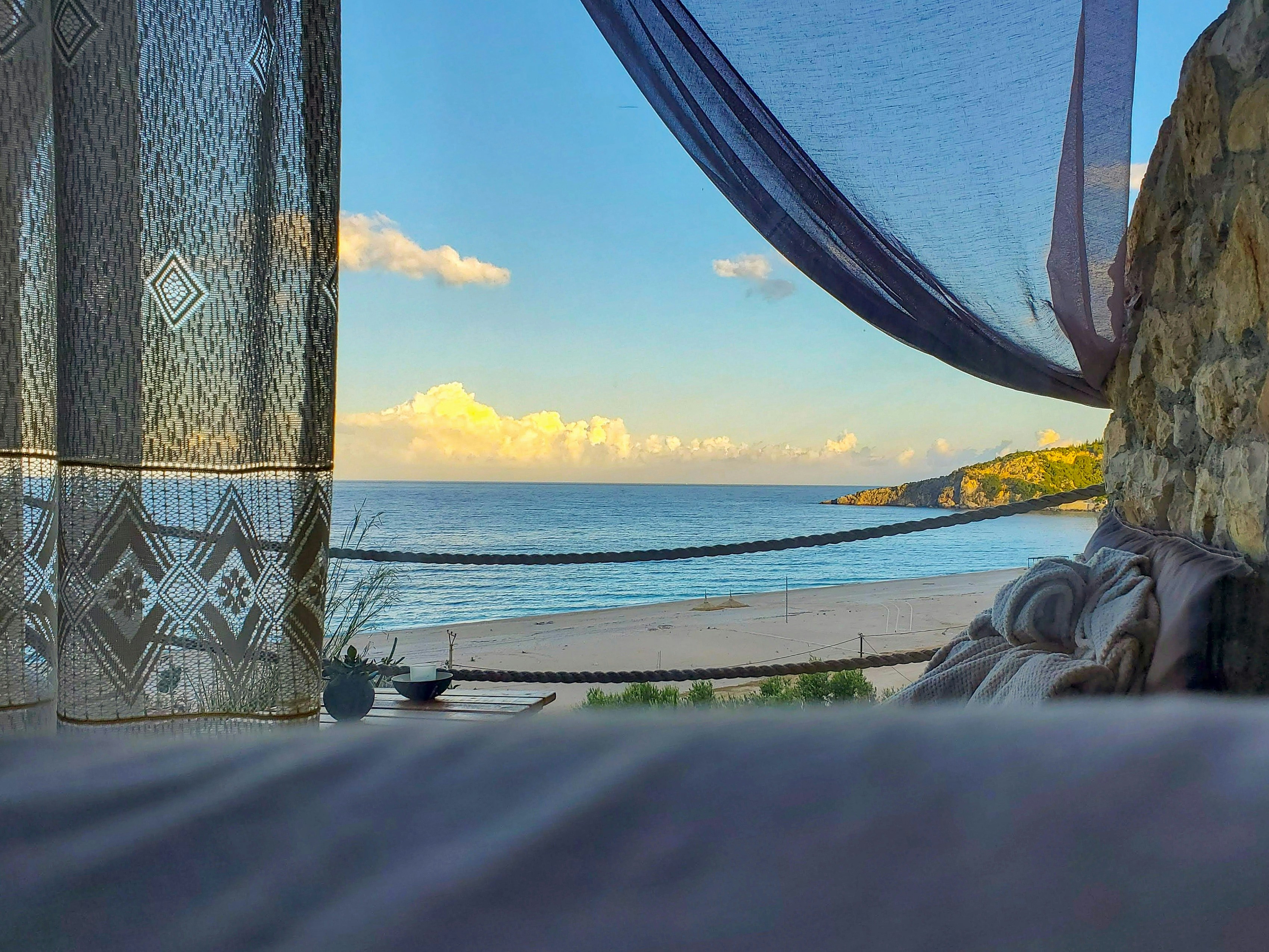 a view of the ocean from inside a tent, 