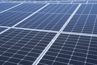 Close-up of high-efficiency bifacial solar panels gleaming under bright sunlight.