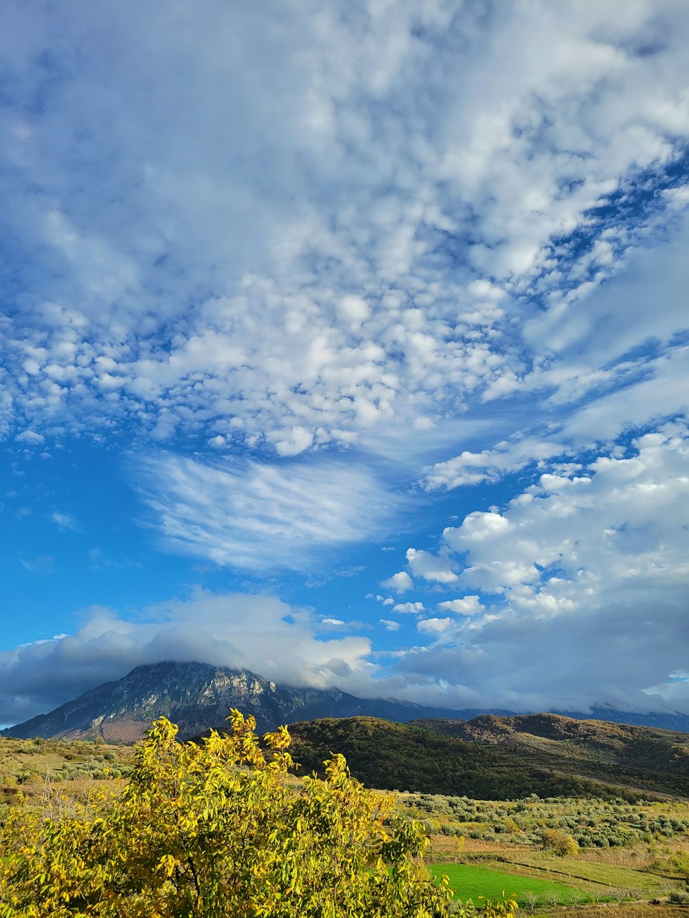 Una vista de una montaña con nubes en el cielo