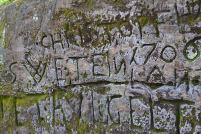Ancient runes carved into rugged stone with moss growing gently around