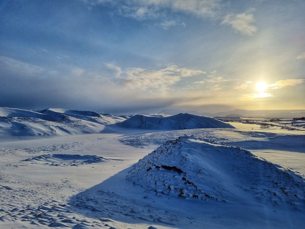 the sun shines through the clouds over a snowy landscape