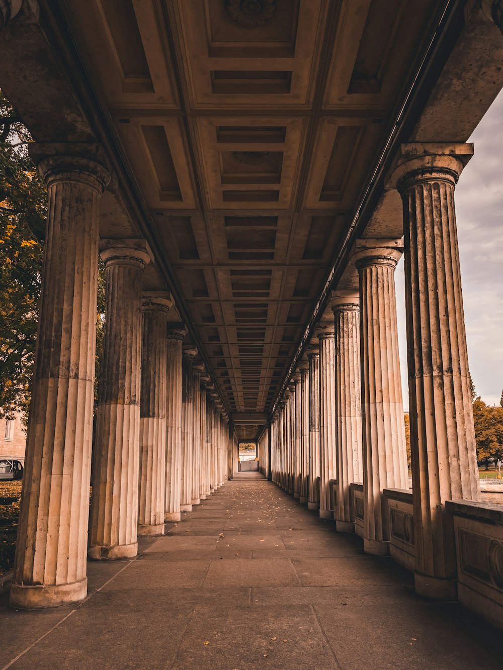 a row of pillars under a bridge on a cloudy day
