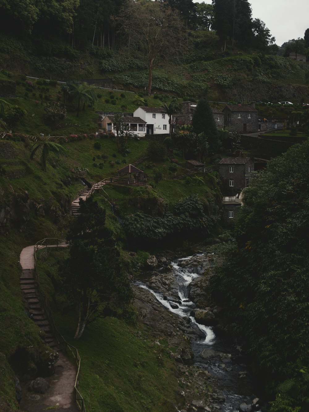 a white house sitting on top of a lush green hillside