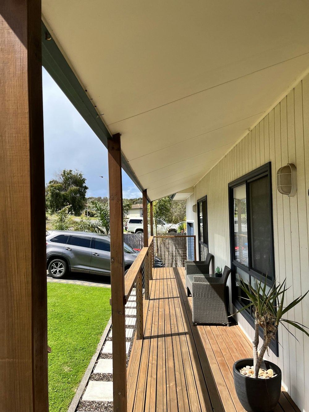 a porch with a plant on the side of it