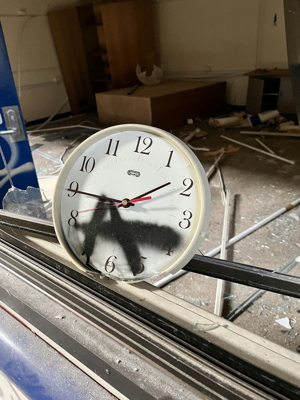 a clock with a shadow of a bird on it