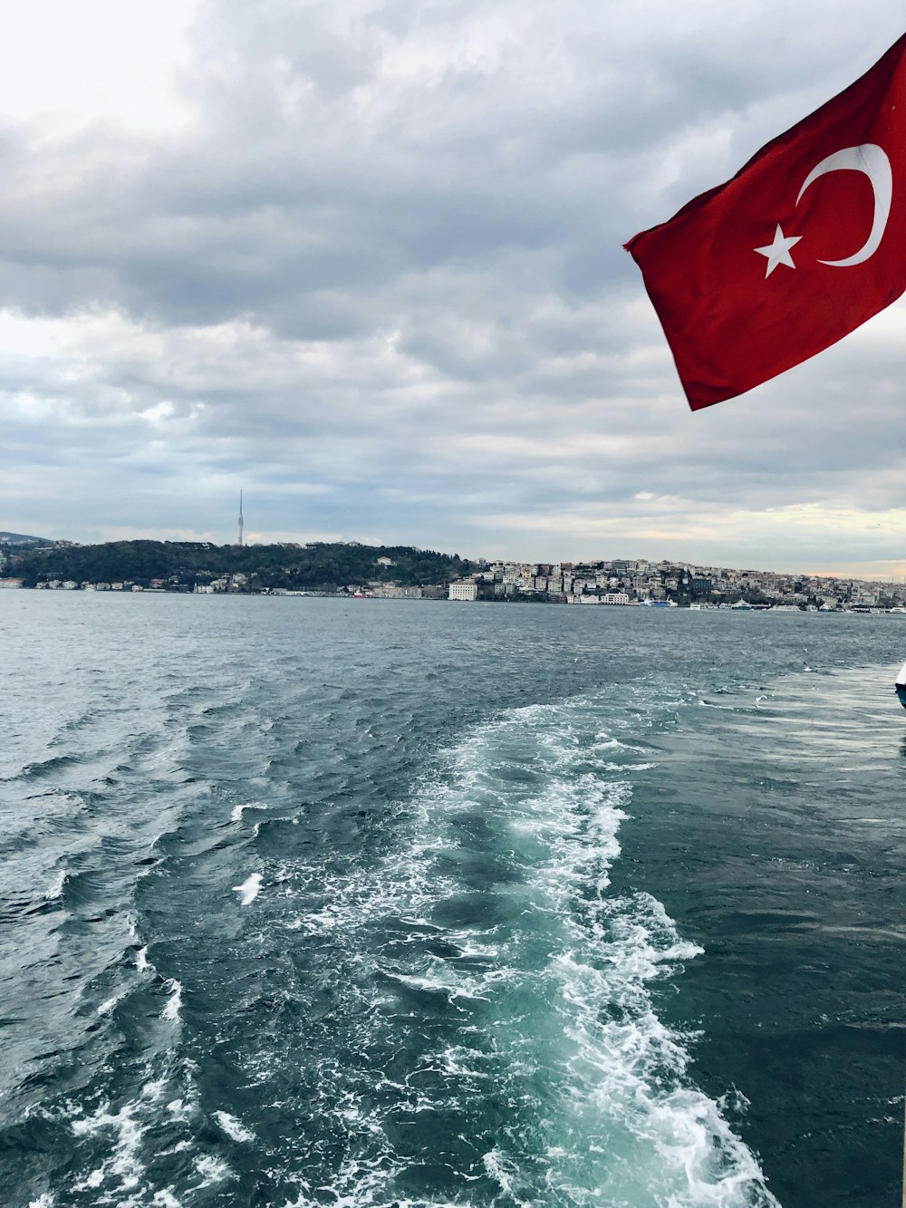 a turkish flag flying over a boat in the water