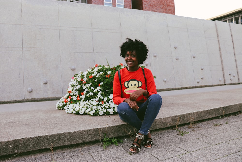 a woman sitting on a curb with a frisbee