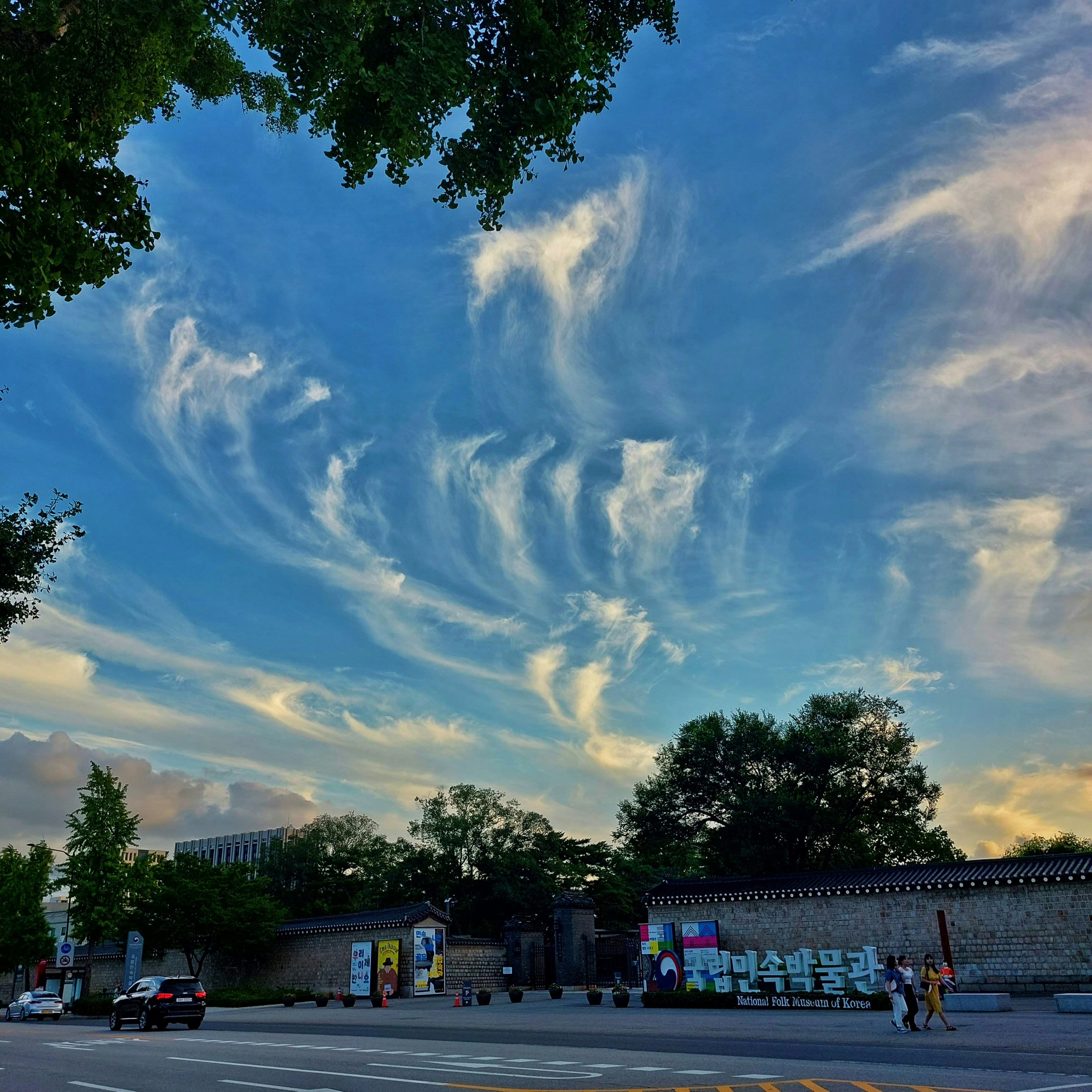 a blue sky filled with clouds over a parking lot