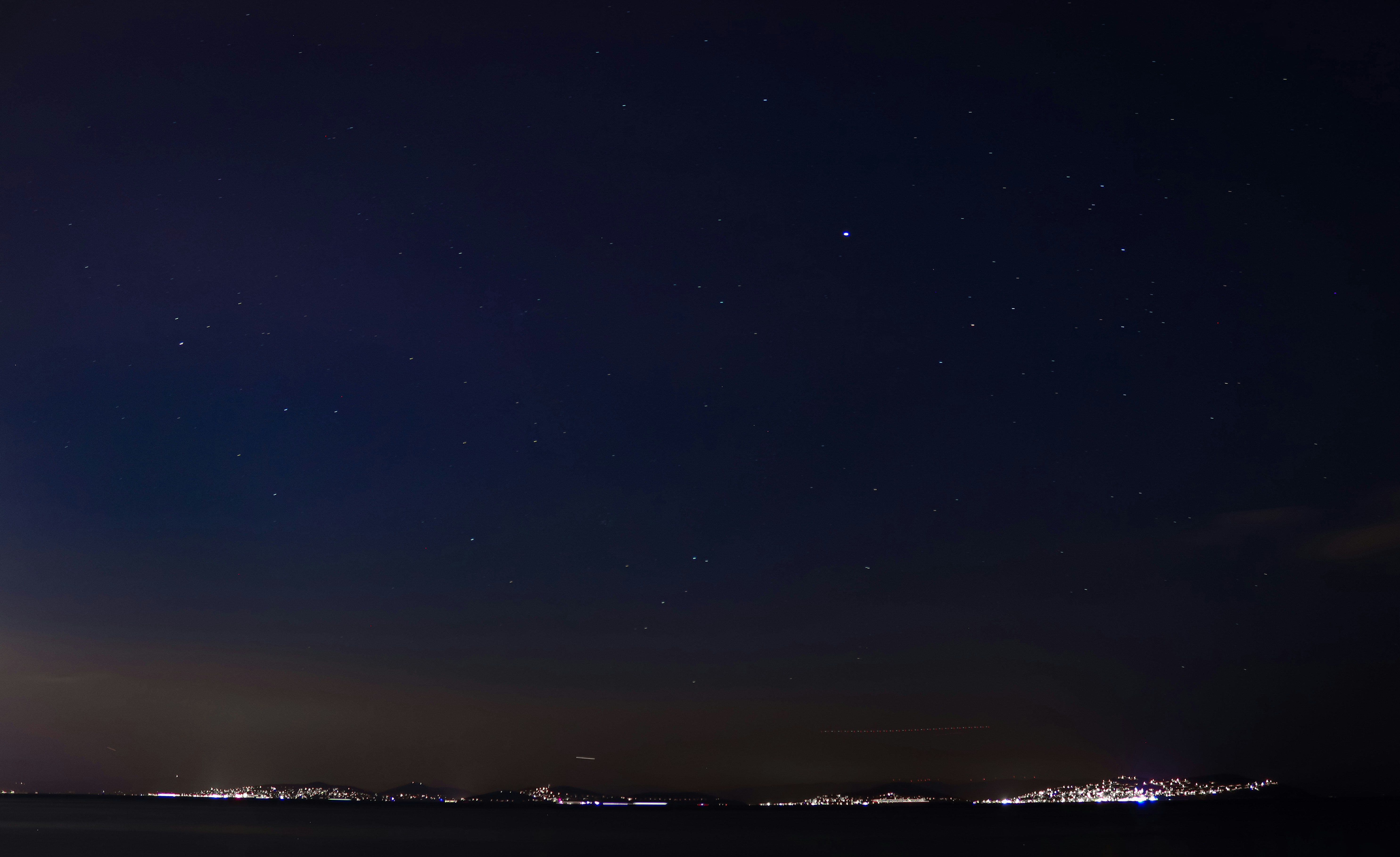 a night sky with a few stars above a city