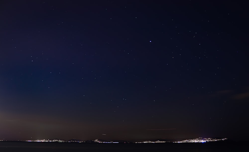 Un cielo nocturno con algunas estrellas sobre una ciudad