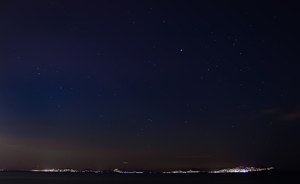 a night sky with a few stars above a city