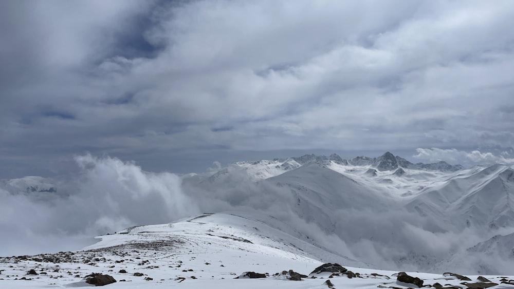 a snow covered mountain with clouds in the sky