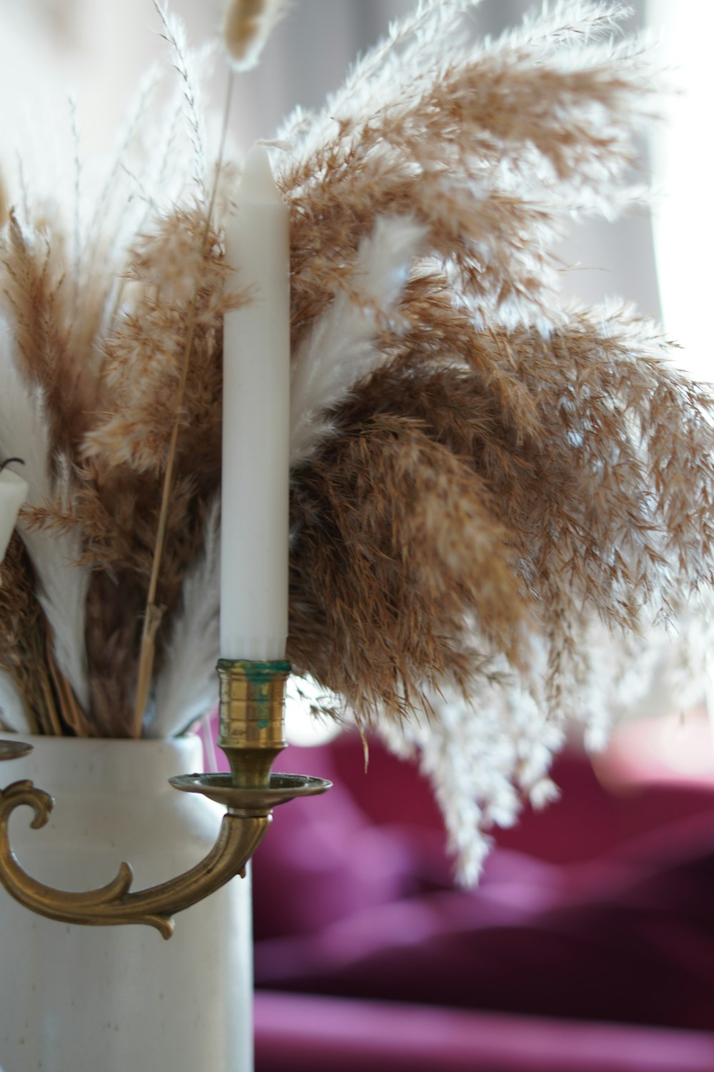 a white vase with some brown and white feathers in it
