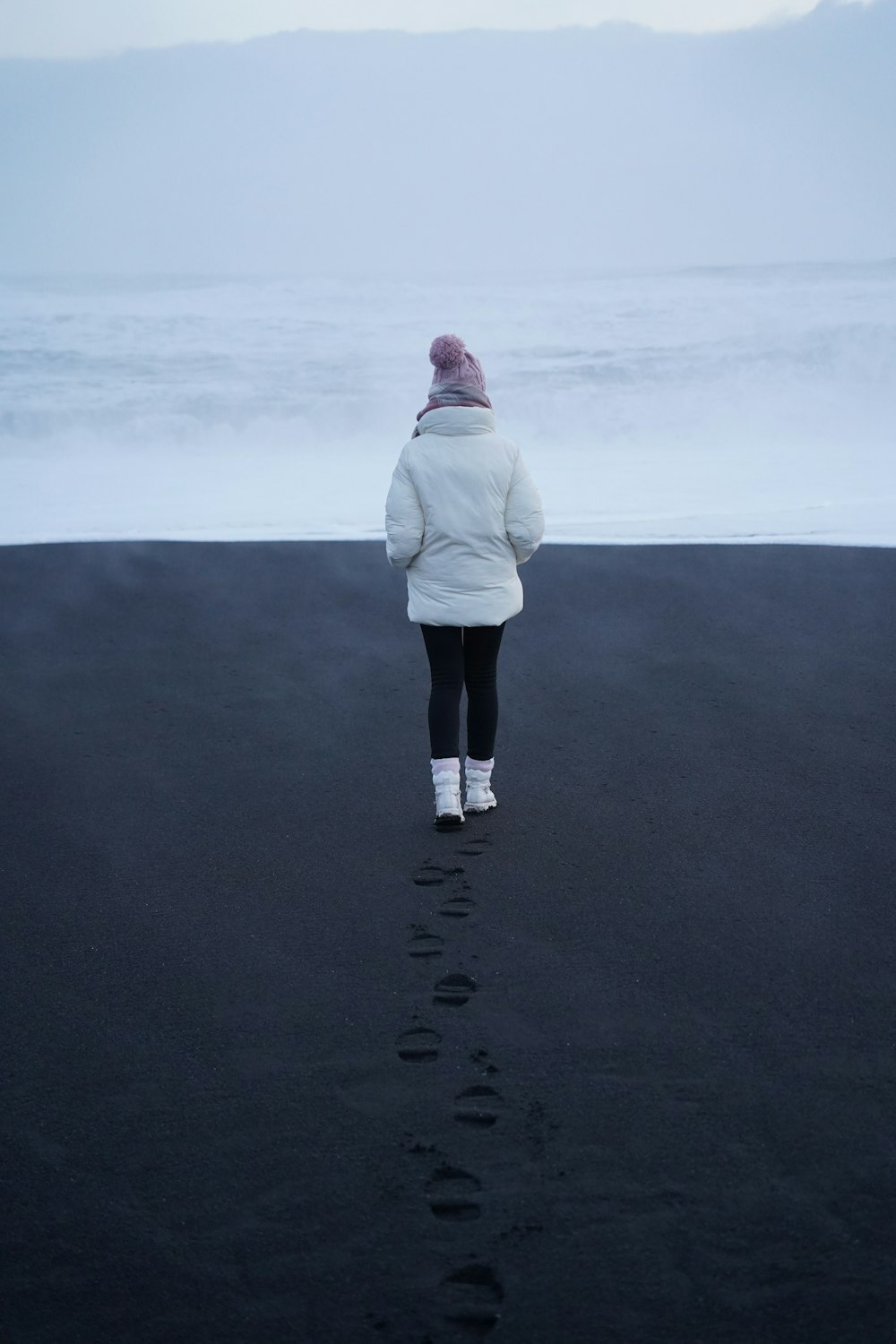 a person standing on a beach looking at the ocean