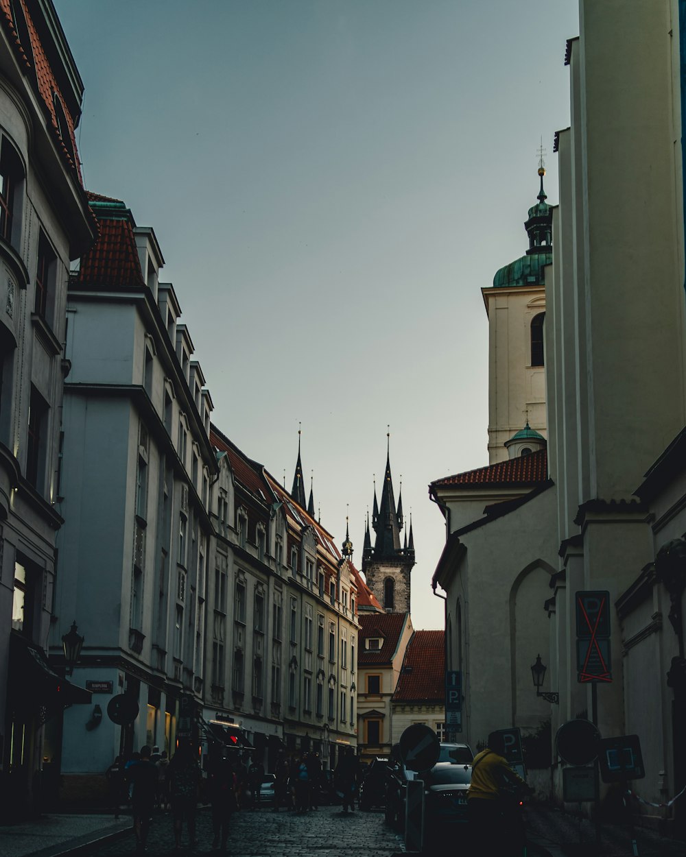 a city street lined with tall buildings and a clock tower