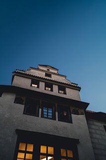 Evening photo of a completed roof with warm interior lights glowing through windows