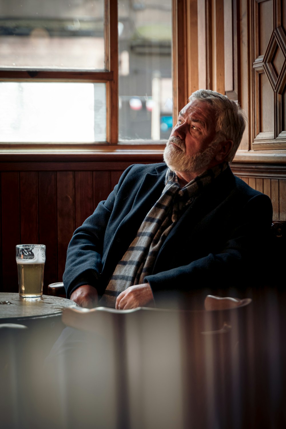 a man sitting at a table with a glass of beer