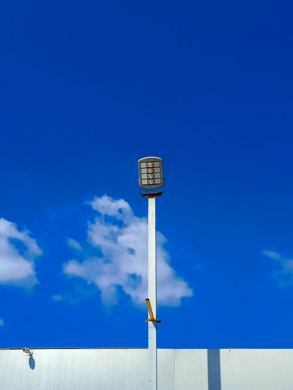 a clock on top of a tall white pole
