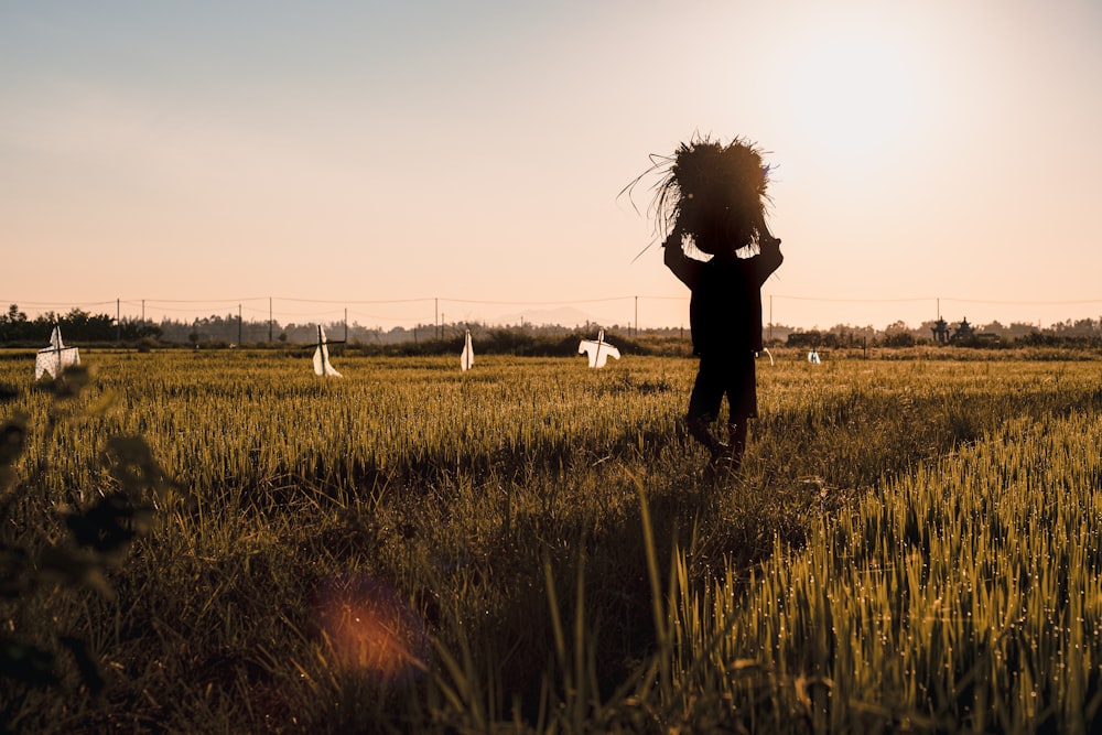 a person standing in a field with their hair in the air