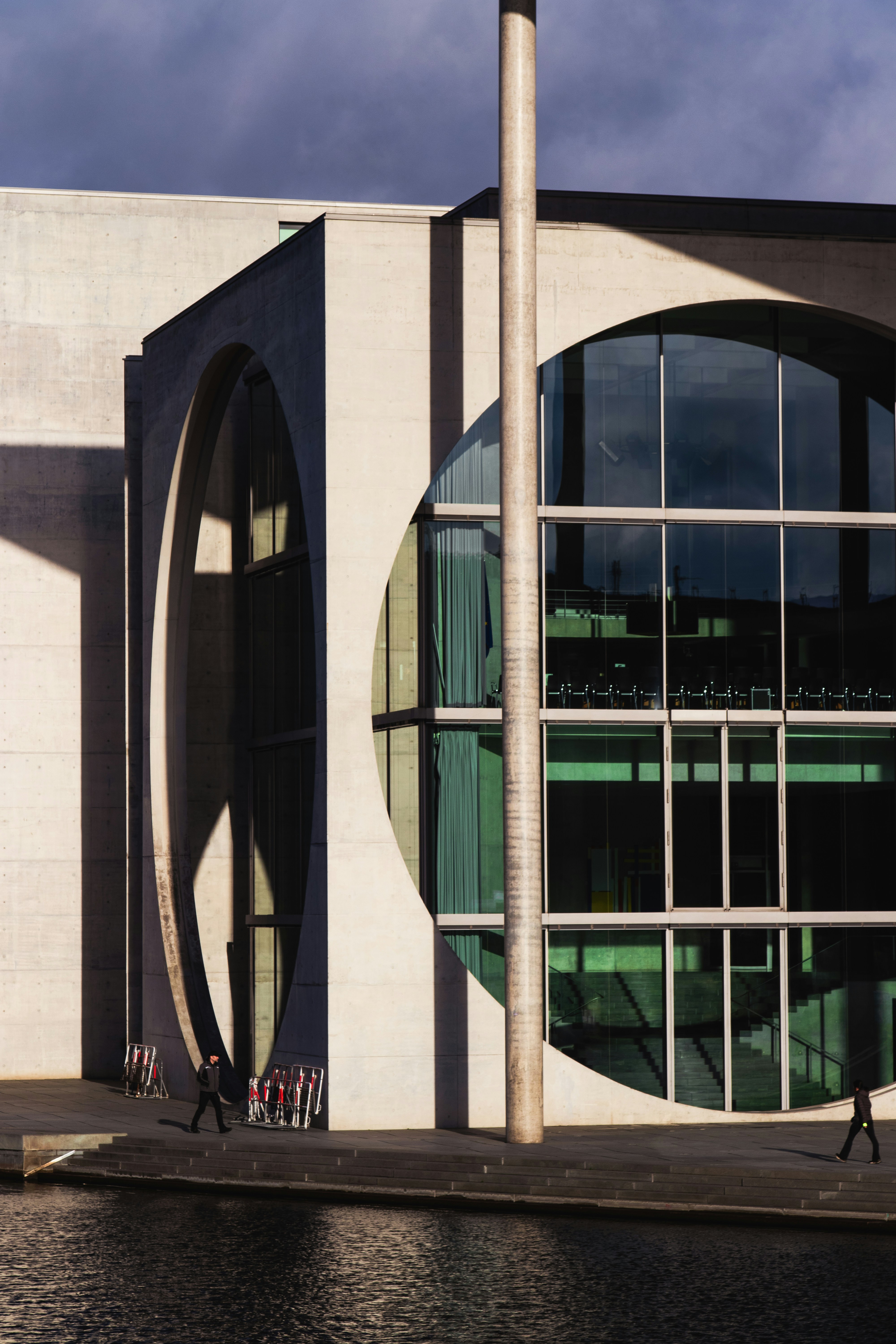 a building with a large circular window next to a body of water